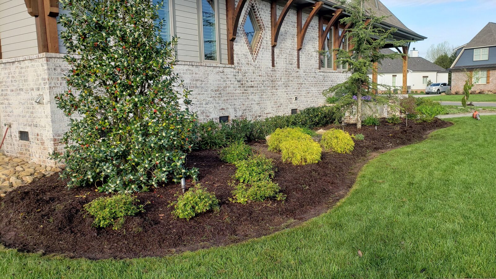 A freshly curbed foundation bed in front of a brick home